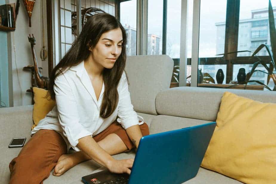 Woman sitting on couch with laptop