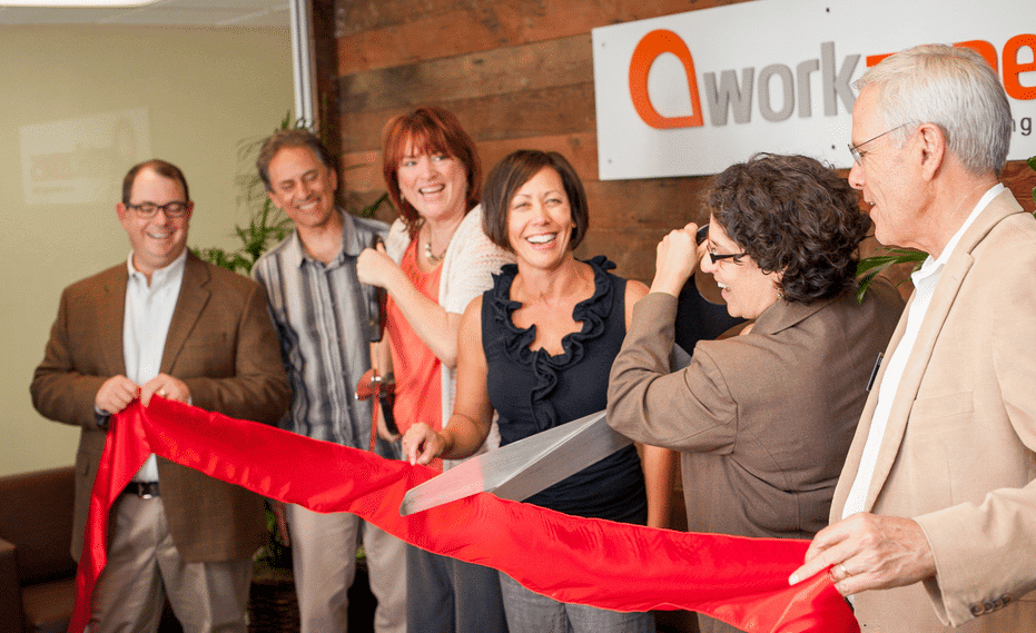People cutting red ribbon at grand opening